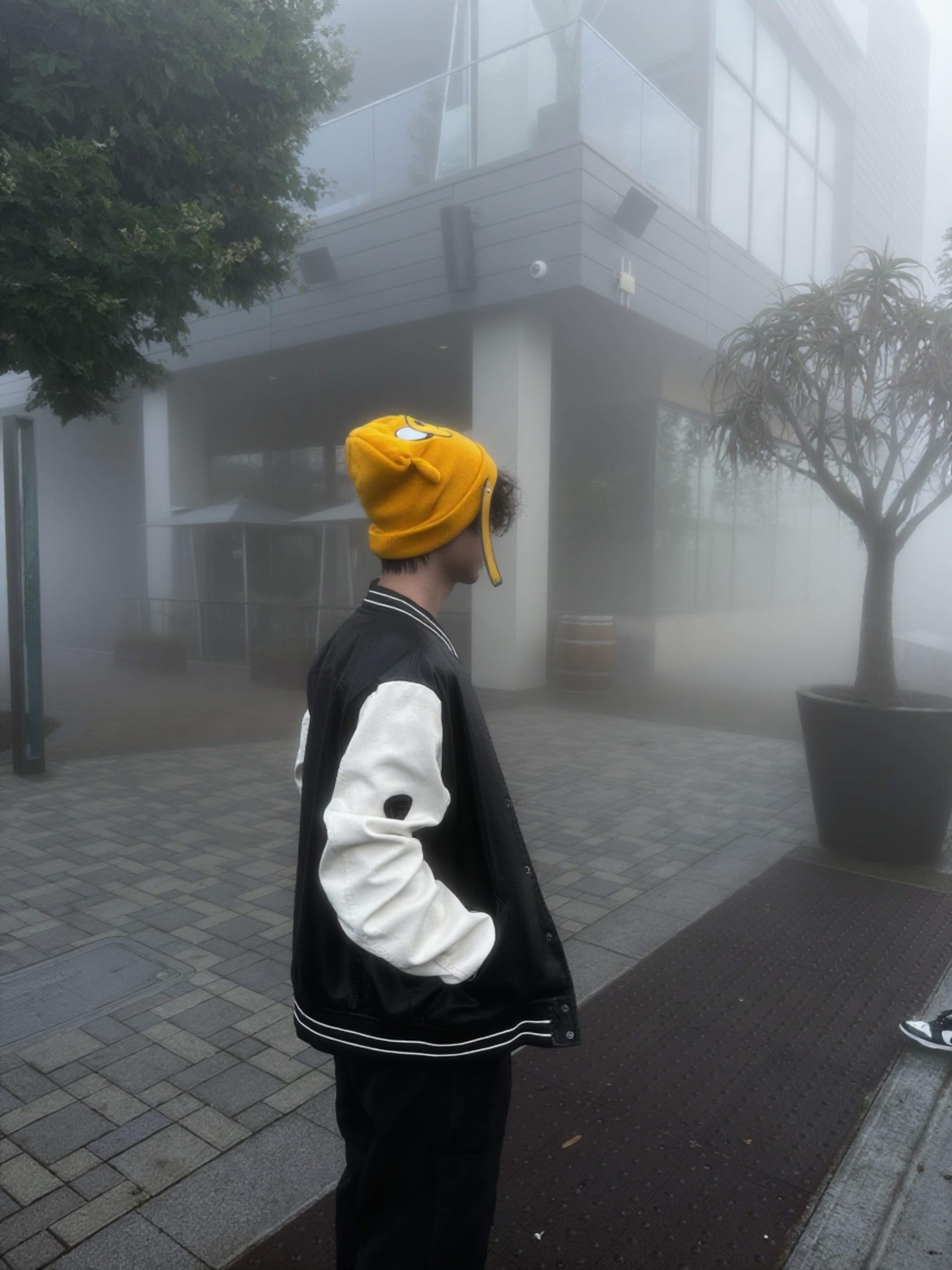 Guy standing outside while the skeis are foggy